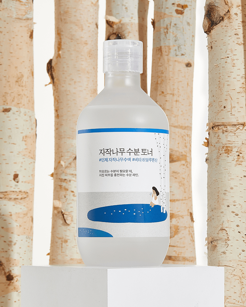 ROUND LAB Birch Juice Moisturizing Toner in front of Korean birch trees